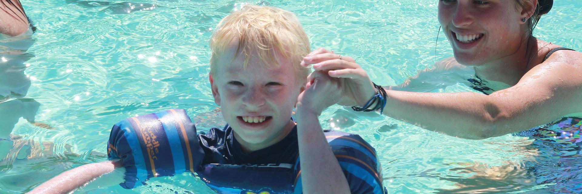 Boy smiling. enjoying the pool.
