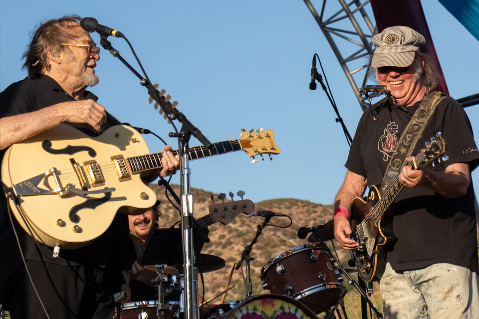 Stephen Stills and Neil Young playing their guitars on stage