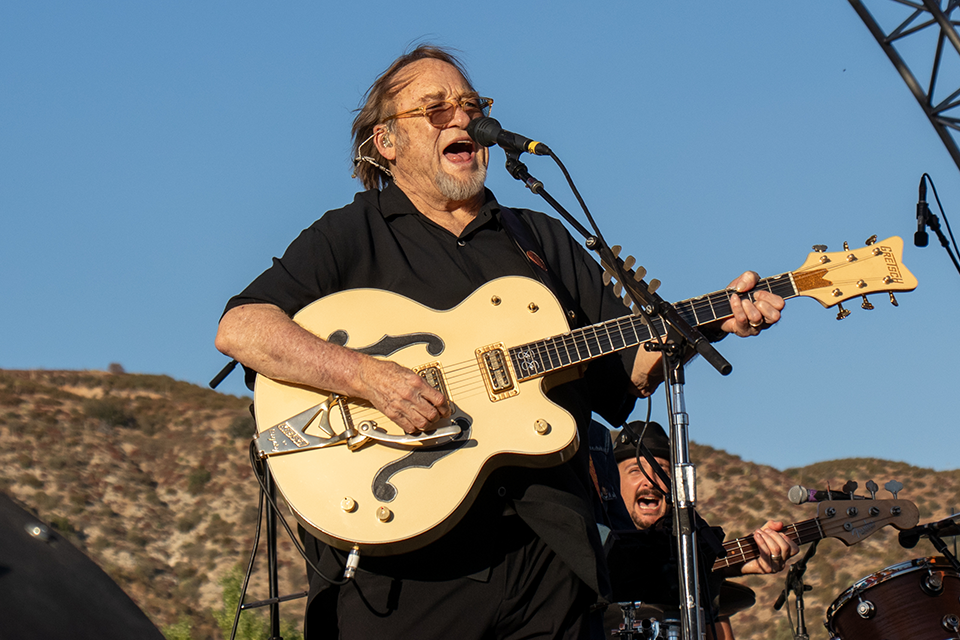 Stephen Stills playing guitar on stage