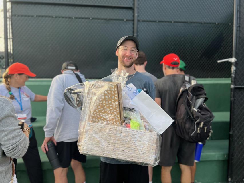 Pickleball winner poses with his prize basket. 
