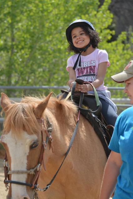 Girl enjoying horseback riding.